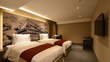 A hotel room with two beds, a wall mural, a flat-screen TV, and a small table.