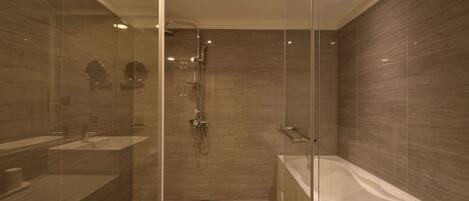 A modern bathroom with a glass-enclosed shower, a standalone bathtub, and a vanity with a mirror.