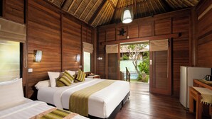 A wooden room with two beds, a bench, a refrigerator, and a door leading to an outdoor area.