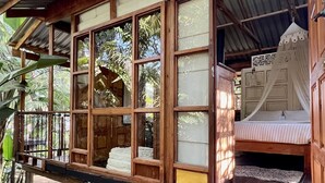 A wooden cabin with a balcony, large windows, and a bed with a canopy. - LoerieRoep (Mbombela)