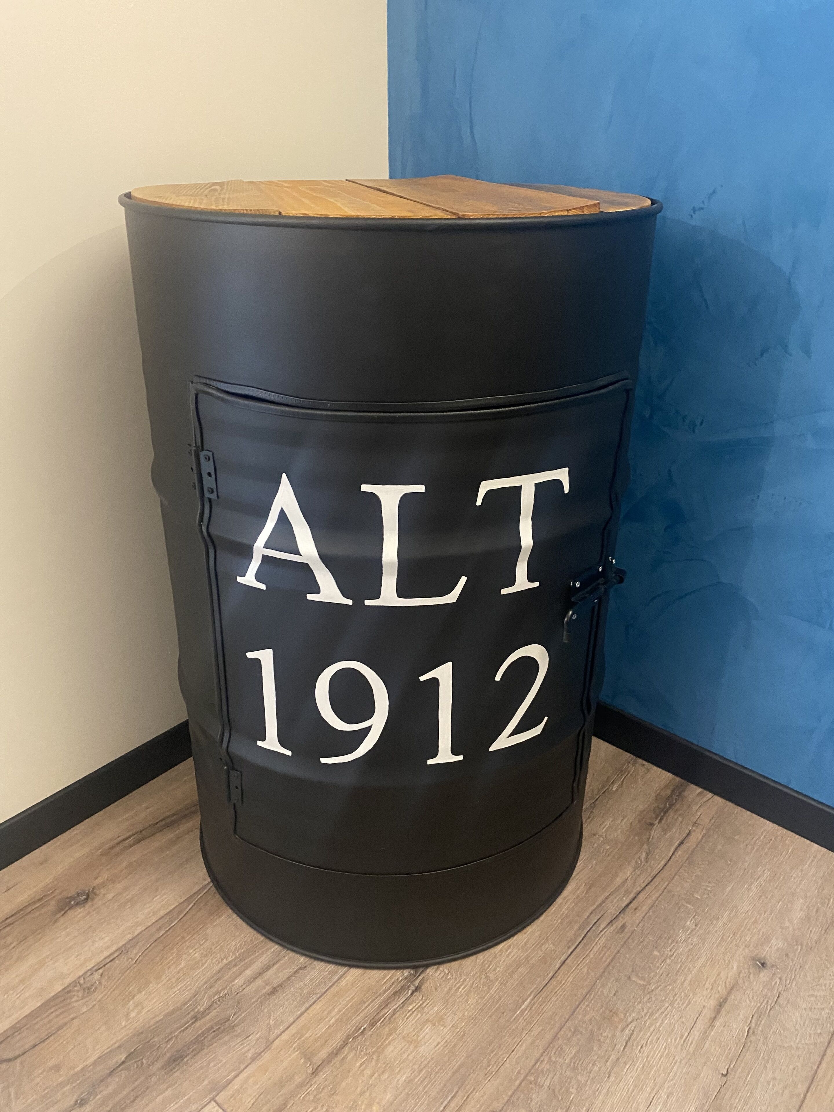 A black barrel with the inscription "ALT 1912" on its side.