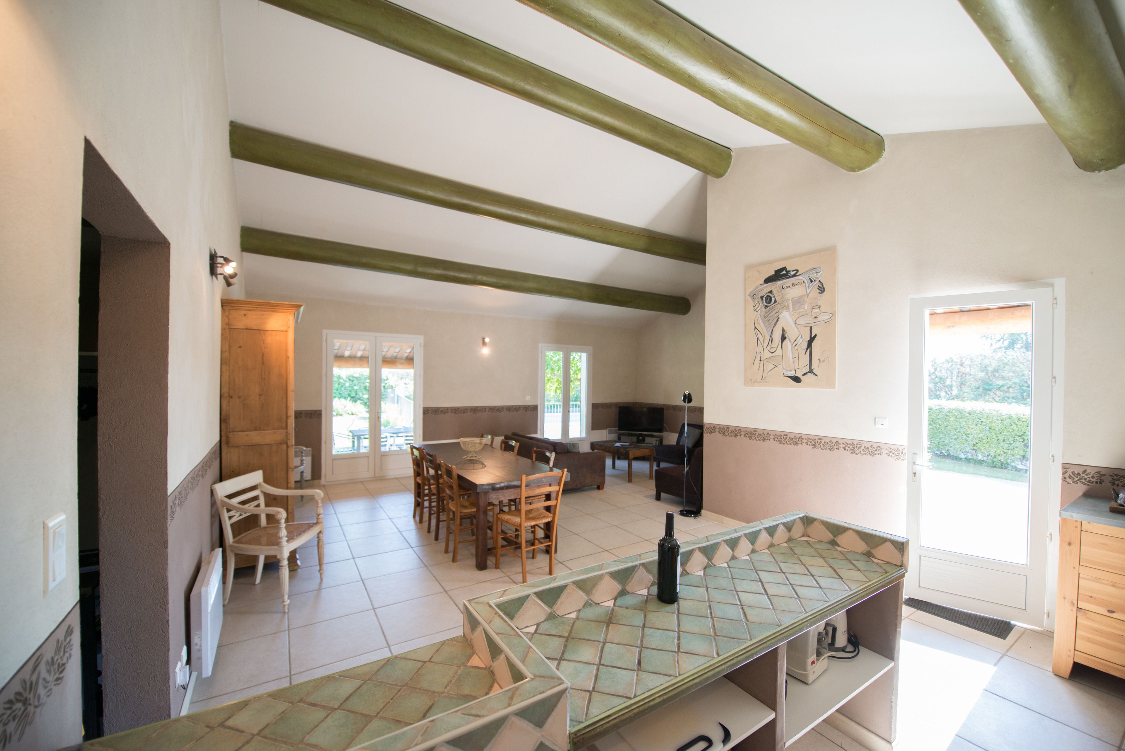 A spacious kitchen with a dining area, wooden furniture, and a tiled backsplash.
