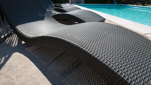 A poolside area with lounge chairs and a pool. - La Ferme Du Gros Noyer (Malaucene)