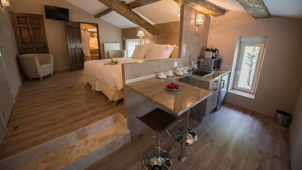 A bedroom with a bed, a desk, and a chair. There is a window and a door. - La Ferme Du Gros Noyer (Malaucene)