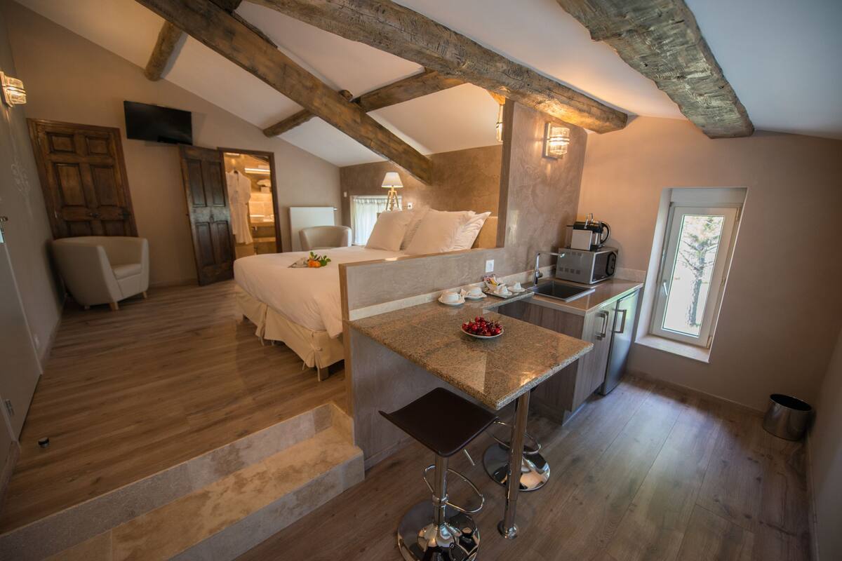 Ein Schlafzimmer mit einem Bett, einem Schreibtisch und einem Stuhl. Es gibt ein Fenster und eine Tür.