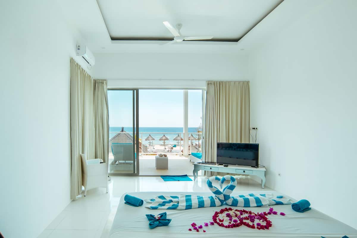 Una habitación de hotel con cama, televisión y vista al mar.