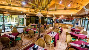 A restaurant with bamboo ceiling, wicker furniture, and a bar area. - Family Country Hotel & Convention Center (General Santos)