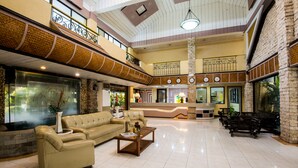 A spacious lobby with a high ceiling, a reception desk, leather seating, and a tiled floor. - Family Country Hotel & Convention Center (General Santos)