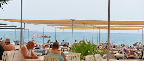 Vlak bij het strand, ligstoelen aan het strand, parasols, duiken