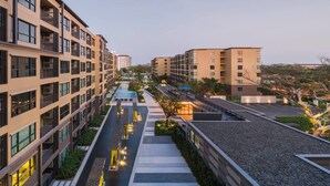 Un complexe d’appartements moderne comprenant plusieurs immeubles de grande hauteur, un jardin sur le toit et une piscine.