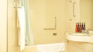 Une salle de bain avec une baignoire, un lavabo et un miroir.