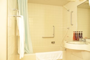 Een badkamer met een bad, een wastafel en een spiegel.