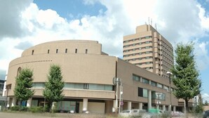 Un bâtiment doté d’une façade incurvée et d’une structure rectangulaire comportant de nombreuses fenêtres.