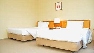 Quarto de hotel com duas camas, uma mesa de cabeceira e um quadro pendurado na parede.