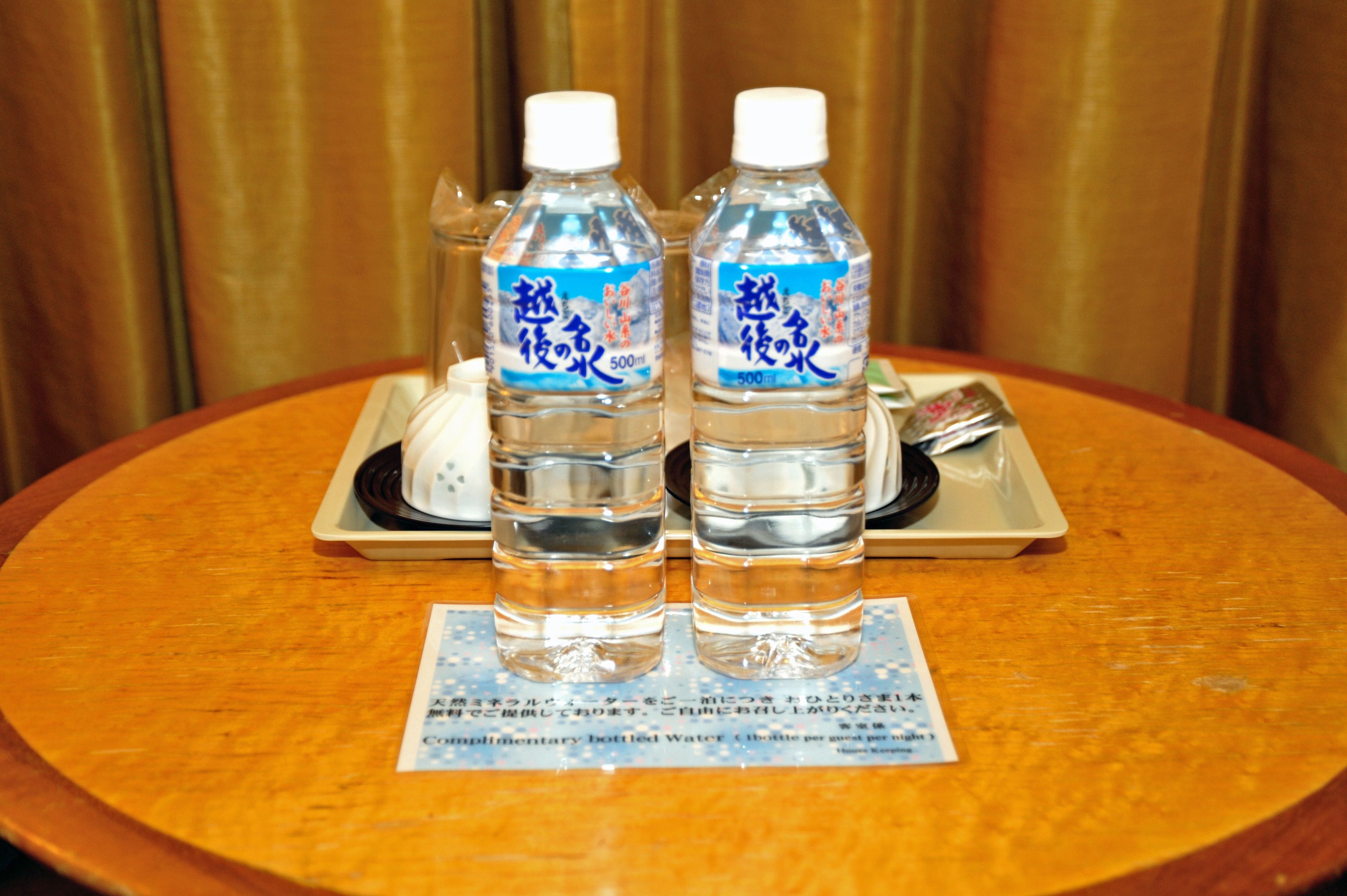 Two bottles of water on a tray with a placemat.