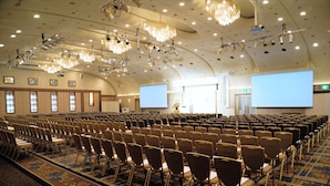 A conference room with rows of chairs, a large screen, and a chandelier. - Hotel New Otani Nagaoka (Nagaoka)