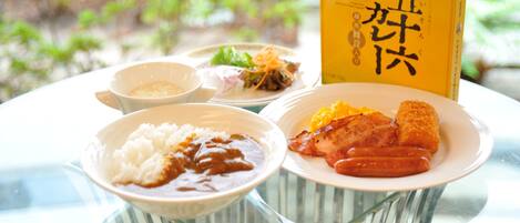 A table with various dishes including rice, beans, and meat, and a book titled "Yamamoto".