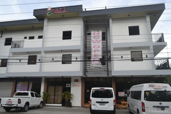 A building with a 'Pearl Suites' sign, a 'NOWOP' banner, and a 'NO TOURIST' sign. - Pearl Suites (General Santos)