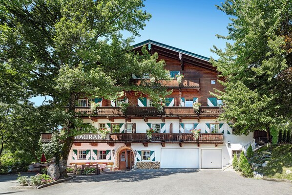 A traditional chalet-style building with multiple balconies, a restaurant sign, and a garage.