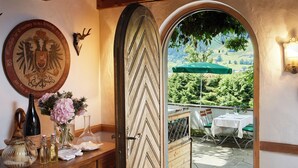 An interior view with a wooden door leading to an outdoor patio area. - Landsitz Römerhof - Hotel Apartments (Kitzbuhel)