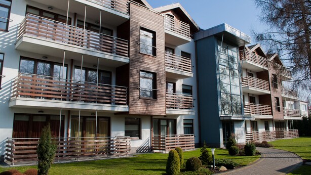 A modern multi-story residential building with balconies, large windows, and a well-maintained lawn. - Baltic Sol (Wladyslawowo)