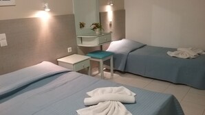 A hotel room with two beds, a small desk, a mirror, and a nightstand. - Ilona Apartments (Chania)