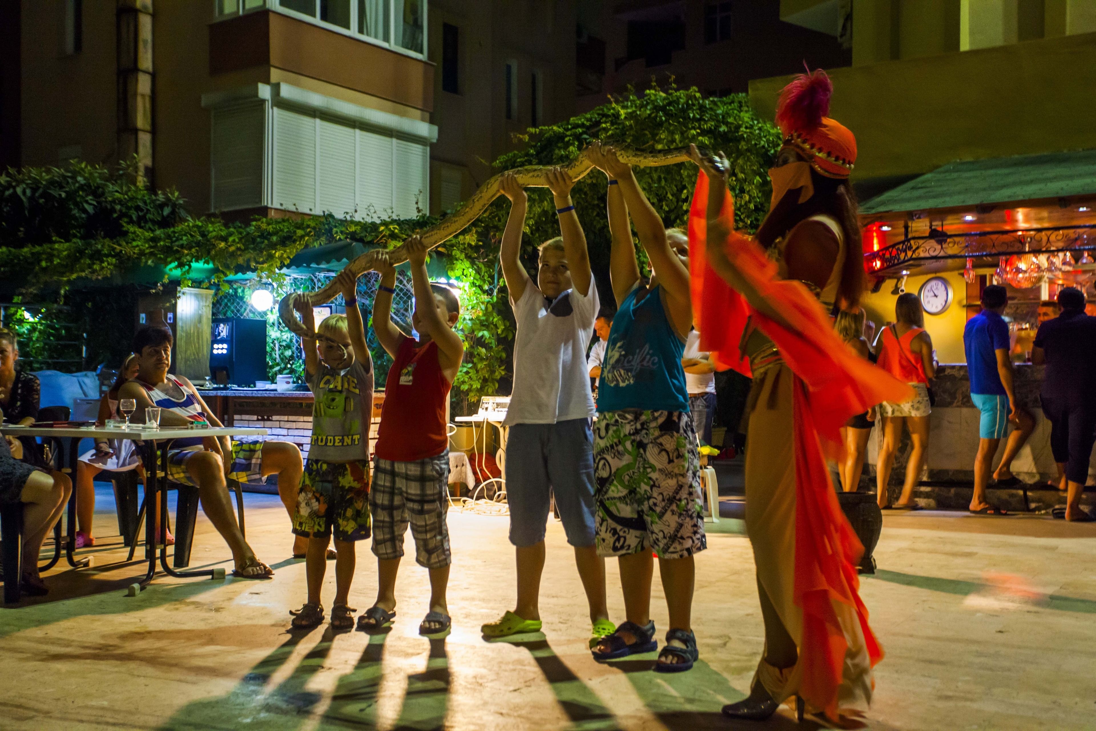 A group of people performing a dance with a snake.