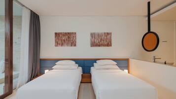 Ein Hotelzimmer mit zwei Einzelbetten, einem großen Spiegel und zwei abstrakten Wandbildern.