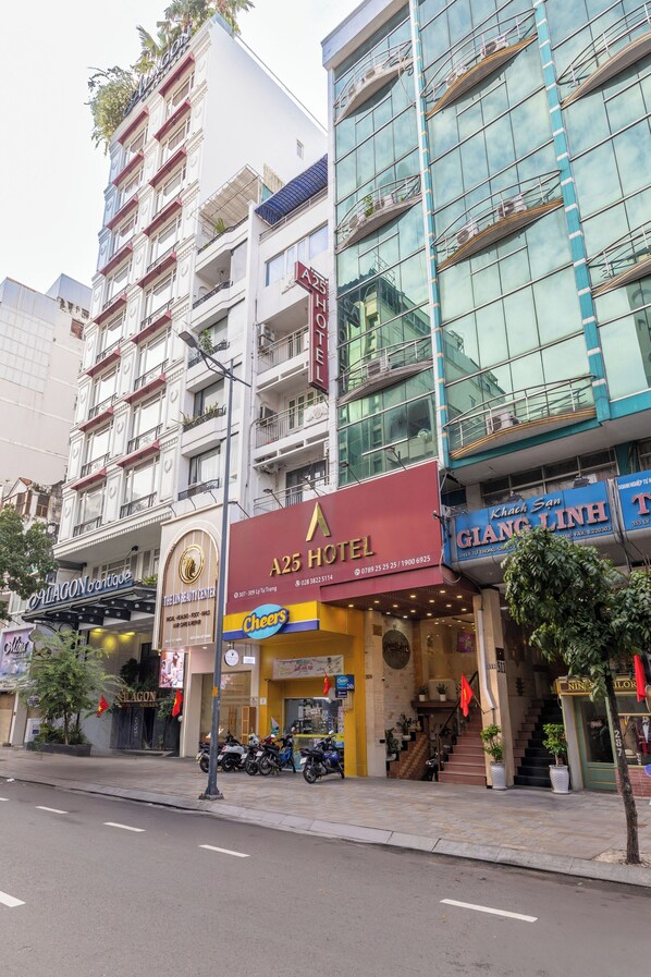 A multi-story hotel with a modern facade, a visible staircase leading to the entrance, and a sign indicating it is the A25 Hotel. - A25 Hotel - 307 Ly Tu Trong (Ho Chi Minh City)