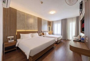 A hotel room with two beds, a wooden headboard, a bedside table with a lamp, a TV, and a minibar. - A25 Hotel - 307 Ly Tu Trong (Ho Chi Minh City)