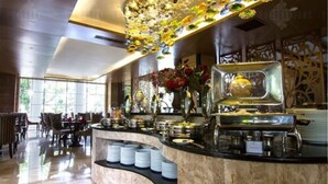 A buffet area with a marble countertop, various food items, and a decorative ceiling. - Belviu Hotel Bandung (Bandung)
