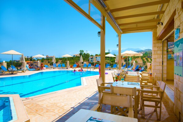 Piscine extérieure, parasols de plage, chaises longues