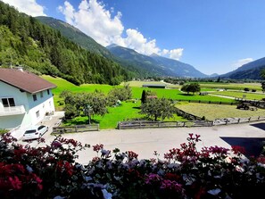 A house with a balcony, a driveway, and a lawn. - Gästehaus Zwischenberger (Obervellach)