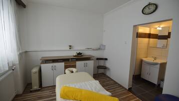 Cozy retreat with a neatly arranged bed, kitchenette, and seating area.