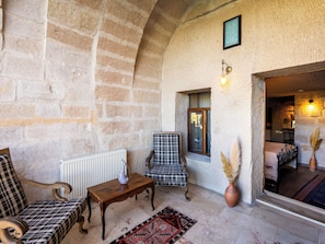 A cozy room with a checkered sofa, a small wooden table, and a patterned rug.
