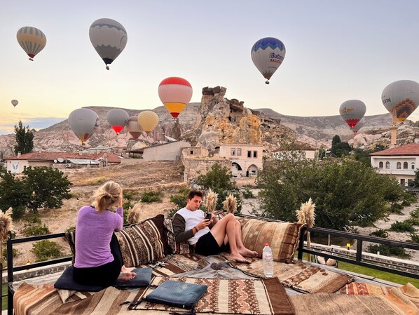 A terrace with a view of a historic village, featuring traditional architecture and a rocky landscape. - Jacob's Cave Suites (Avanos)