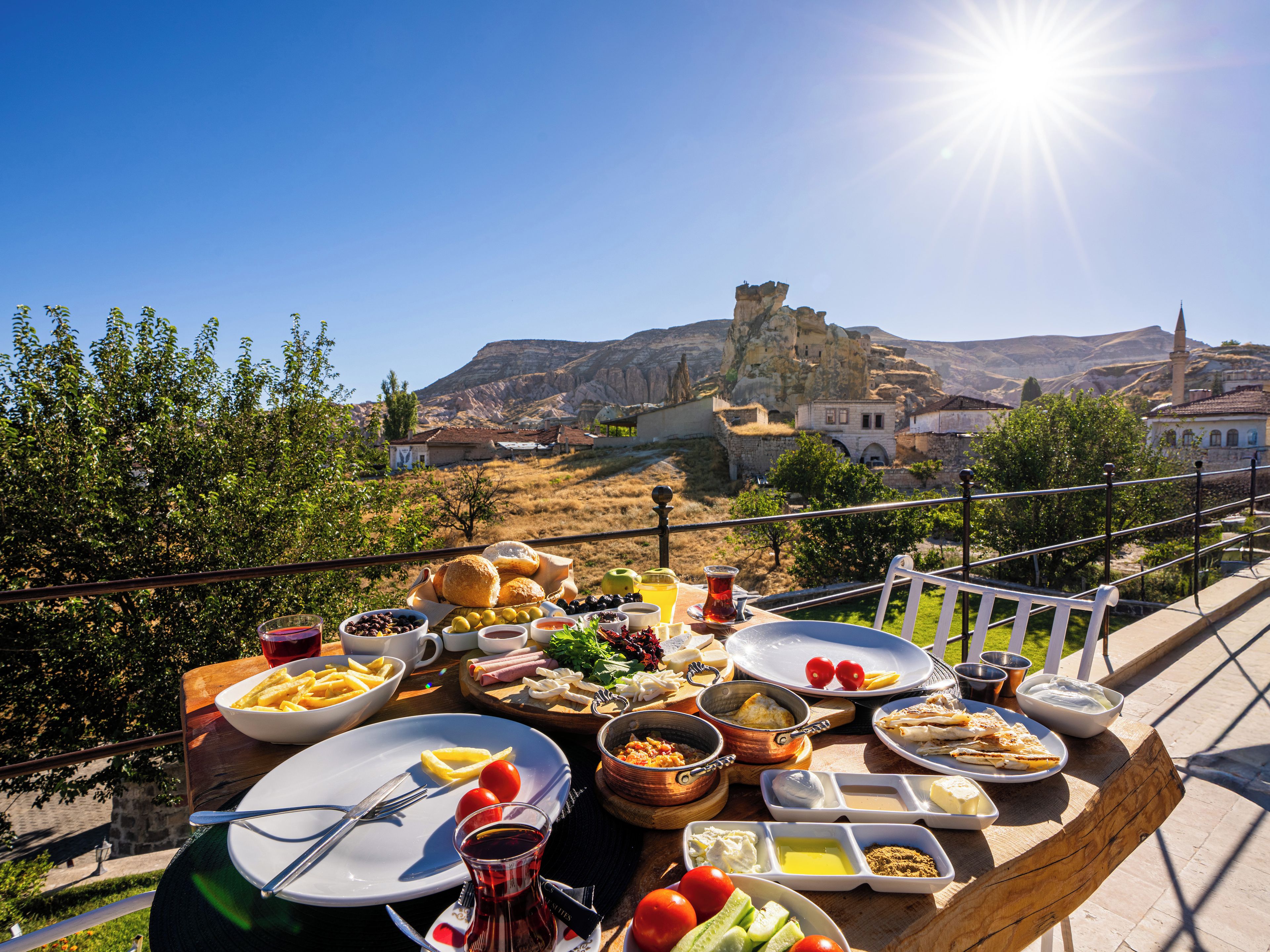A table set with various dishes and a view of a historic town with a castle in the background.