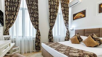 A hotel room with a bed, a desk, and a chair.
