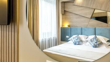 A modern hotel room with a bed, a TV mounted on the wall, and a large window with curtains.