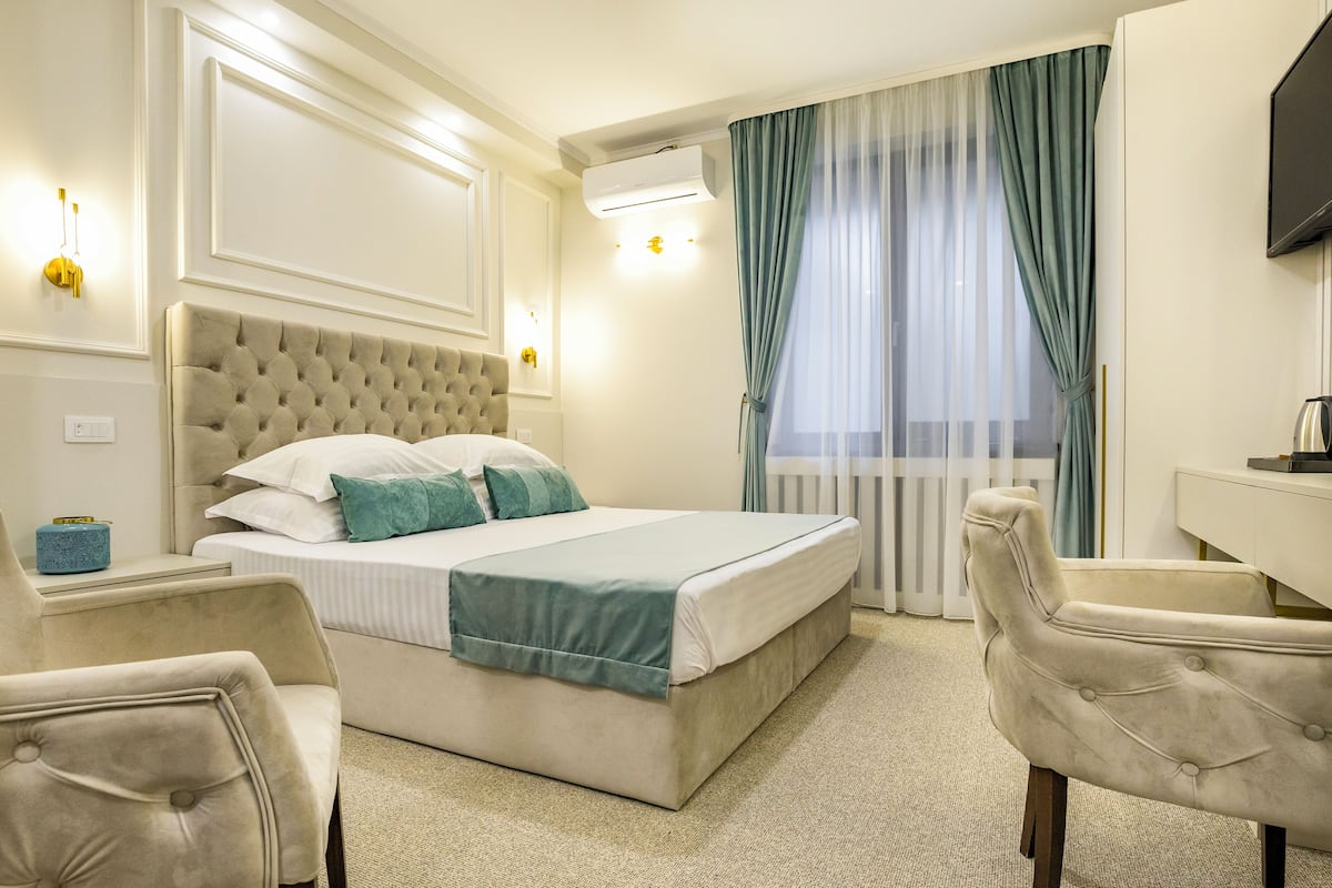Una habitación de hotel con una cama grande, un escritorio y una silla.