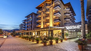 A hotel with multiple balconies, outdoor seating, and a beach view. - Kleopatra Ada Beach Hotel (Alanya)