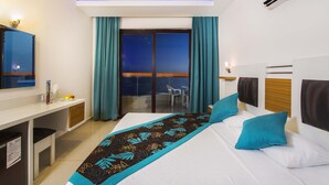 A hotel room with a bed, a desk, a chair, a balcony with a view, and an air conditioning unit. - Kleopatra Ada Beach Hotel (Alanya)