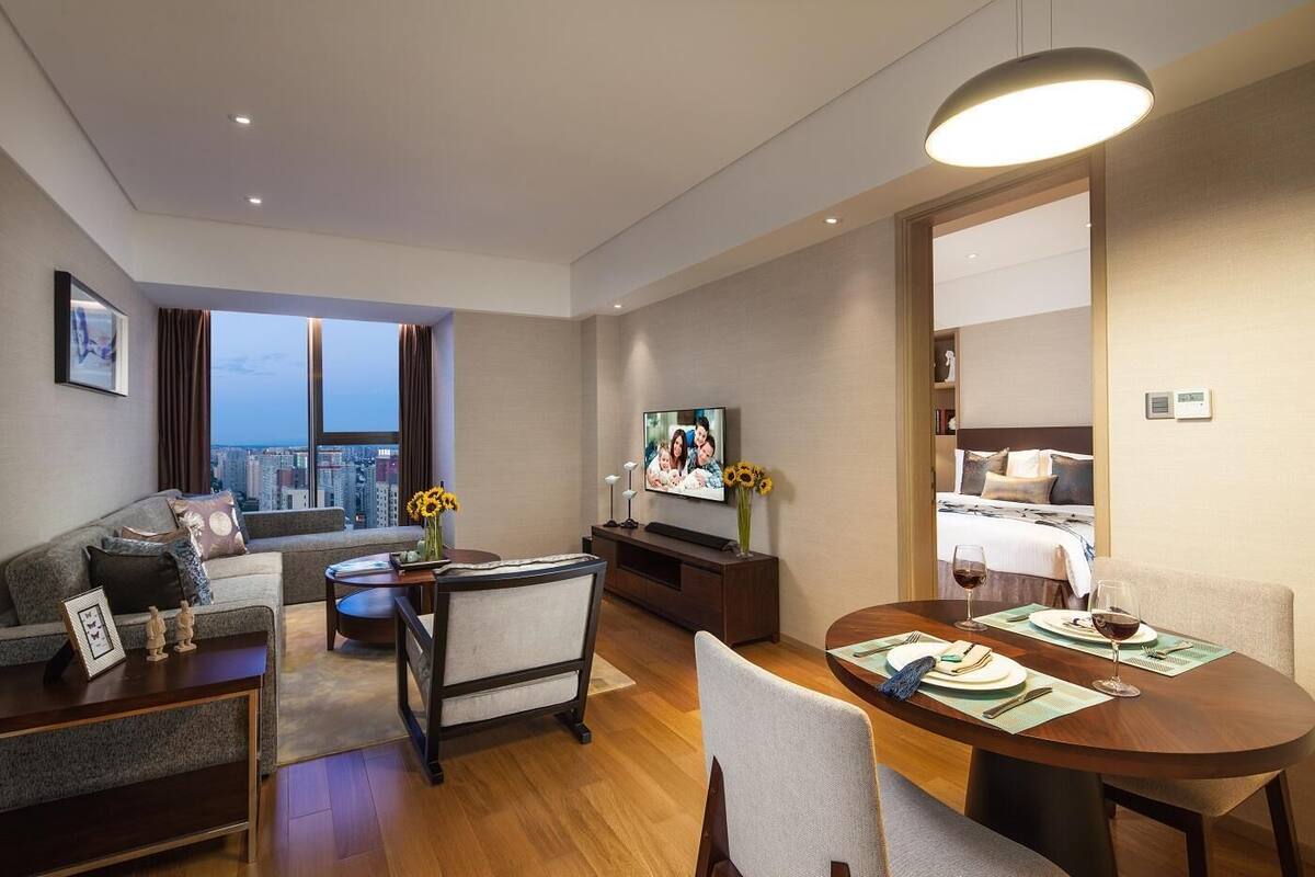 Een moderne hotelkamer met een zithoek, eethoek en een bed.
