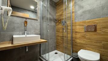 Ein modernes Badezimmer mit einer Duschkabine aus Glas, einem Holzbadezimmer-Möbel und einer Toilette.