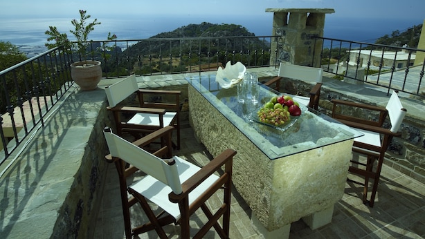 A terrace with a glass table, chairs, and a fruit bowl. - Diktynna Luxury Villas (Ierapetra)