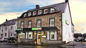 A stone building with a sign for a hotel and a pizzeria. - Hotel Schwan (Eschweiler)