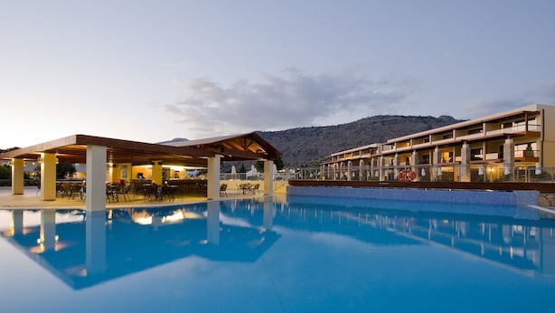 Un hôtel doté d’une piscine, d’un espace extérieur aménagé et offrant une vue sur les montagnes.