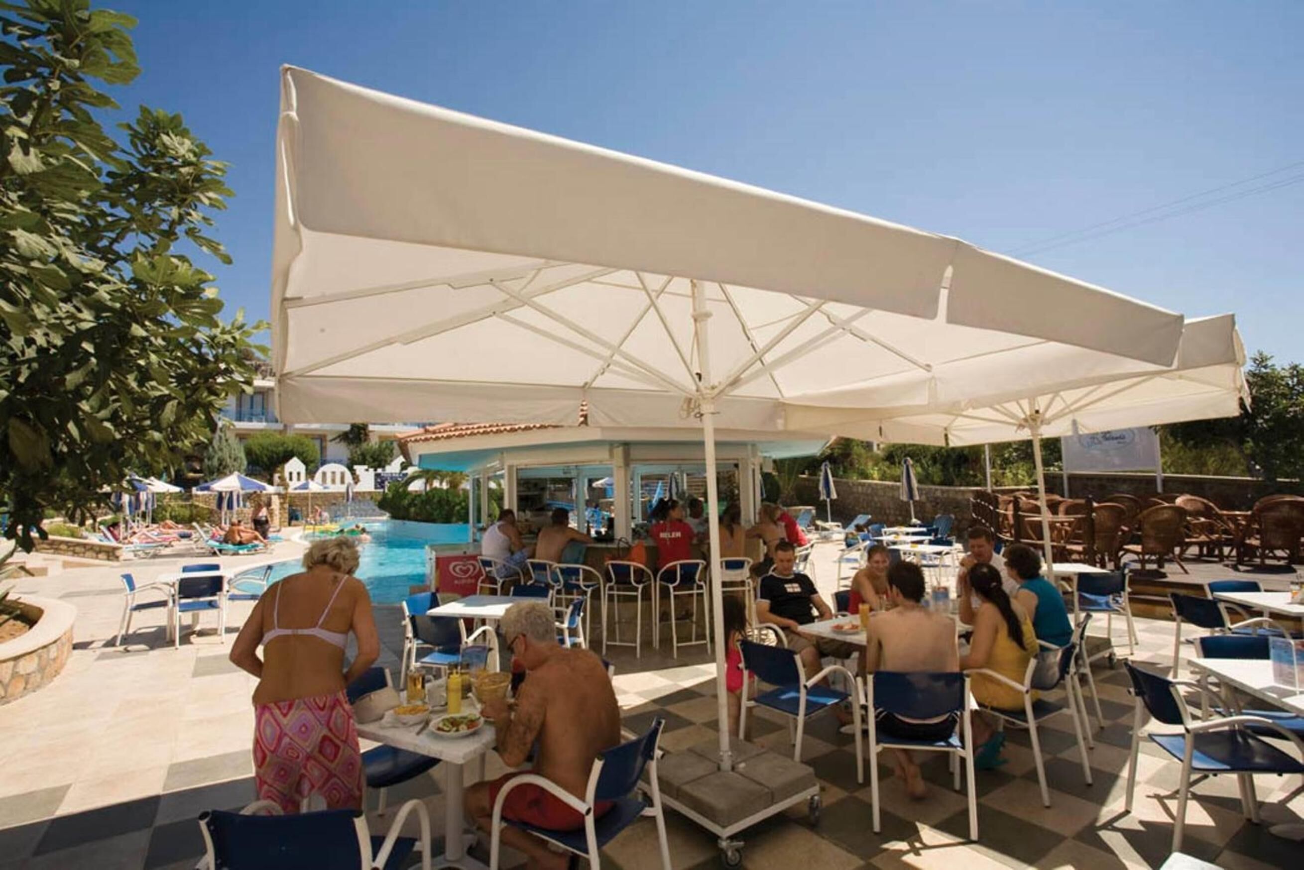 Ein Außenpoolbereich mit Sonnenschirmen und Liegestühlen.
