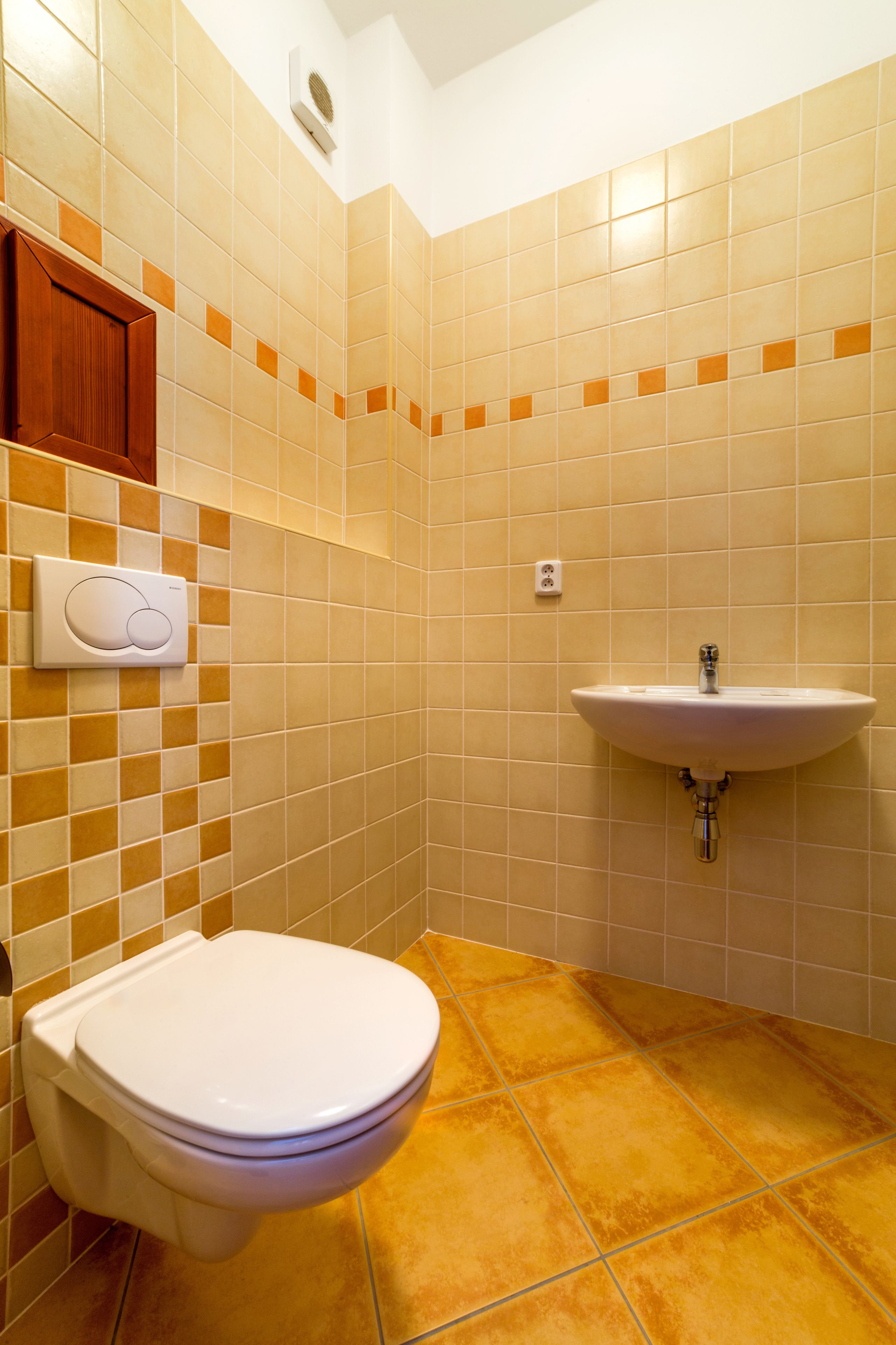 A bathroom with a toilet, sink, and a hand dryer.