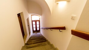 Una escalera con barandilla de madera y un aplique en la pared.
